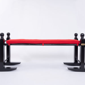 8' Charleston green joggling board with bright red cushion on white background. 