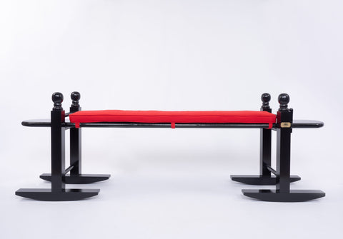 8' Charleston green joggling board with bright red cushion on white background. 