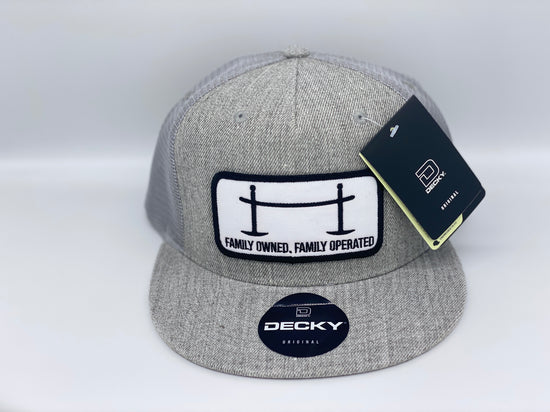 Front view of The Joggle Factory grey trucker hat with Family Owned Family Operated on the patch.